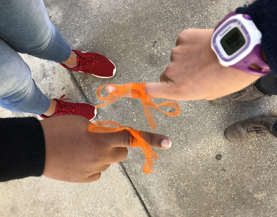 Sophomores Amelia Anello and Layla Mathews tie their ribbons in support of the Parkland victims.