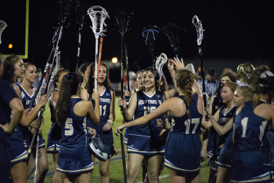 The girls lacrosse team cheers following their game against Edgewood.