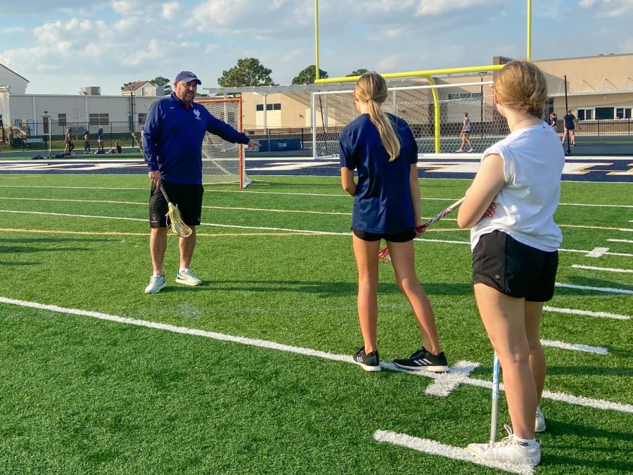 Coach Phillips explains a drill for the girls lacrosse team. Phillips returns back to his coaching position after six years.