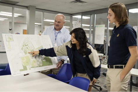 Dr. Greg Spencer,  junior Alejandra Acerco, and junior Garret Tinker look over the blueprints of the current parking lot in search of potential renovations.