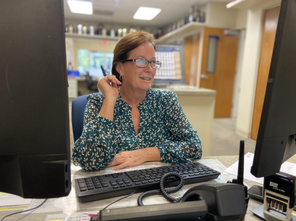 Receptionist and Attendance Administrator Stacey Hewatt checks for completed attendance. Hewatt has worked at Holy Trinity for two years offering smiles to everyone who walks through the door. 
