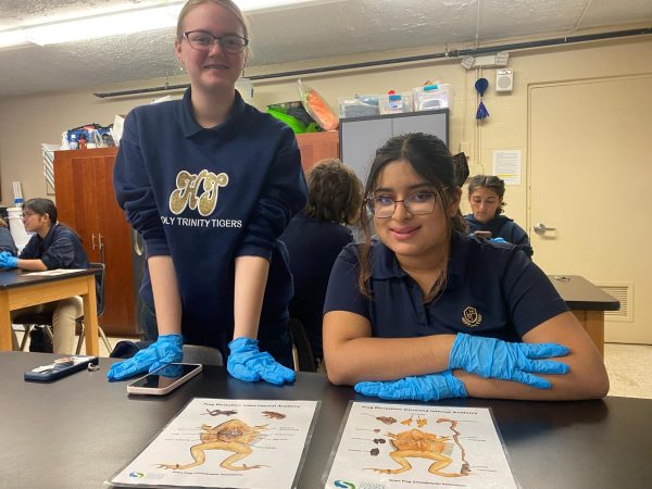 Senior Sofie Alikhan and sophomore Sophia Adams are preparing for their frog dissection by studying the internal organs and body structures of the amphibian. 