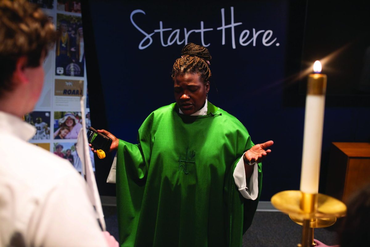 Garcia Barnswell-Schmidt prays with the student volunteers before Eucharist.