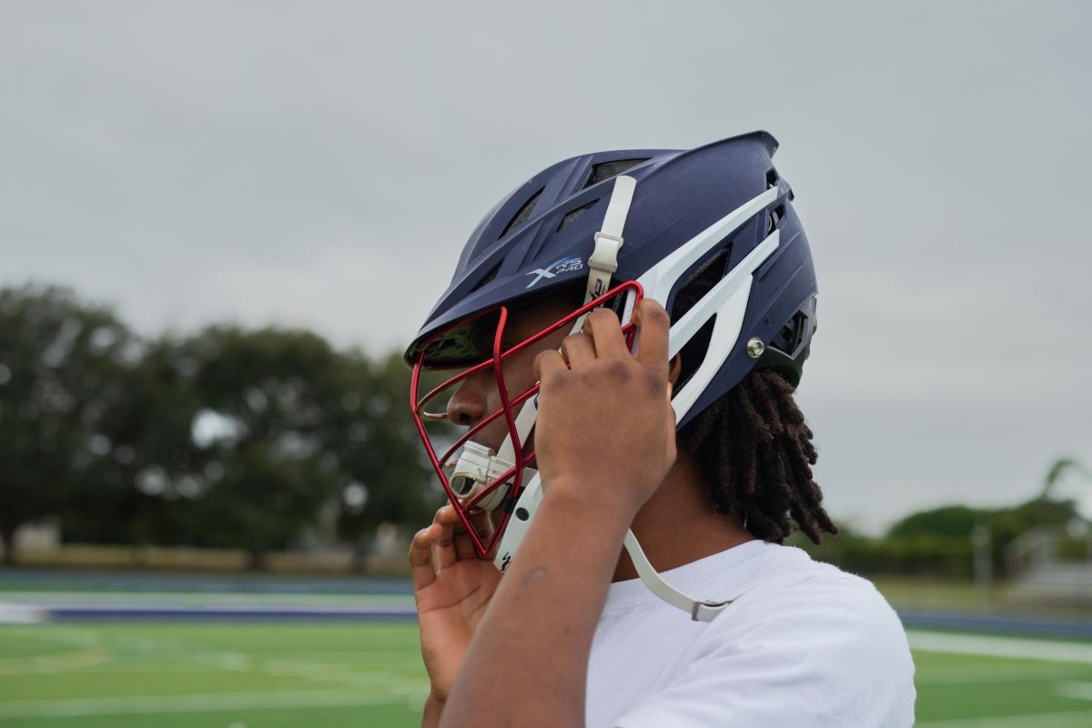 HT Alumni Myles Smith puts his gear on for his workout with current Holy Trinity Lacrosse players at Kelly Stadium on December 9, 2025.